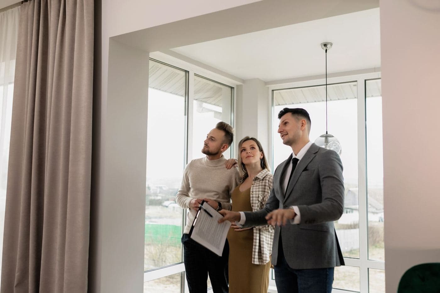 Un asesor inmobiliario muestra un departamento a dos clientes